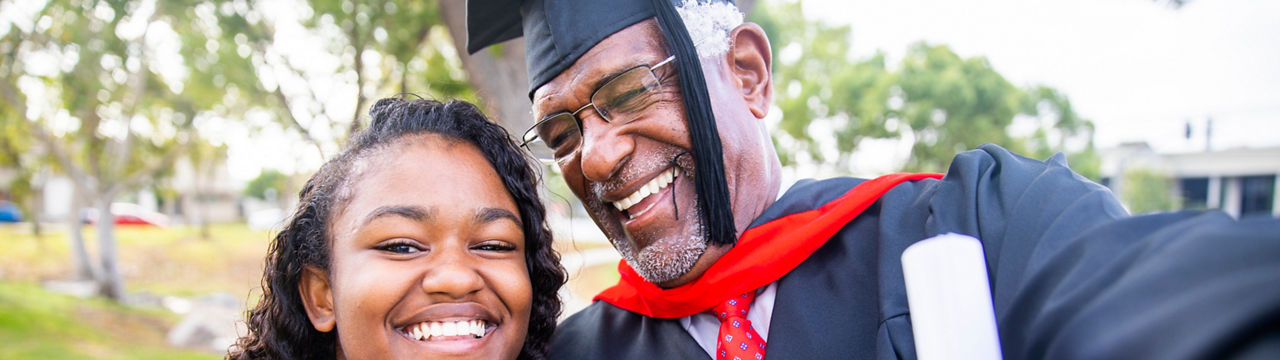 A senior African American man celebrates his graduation with his famly