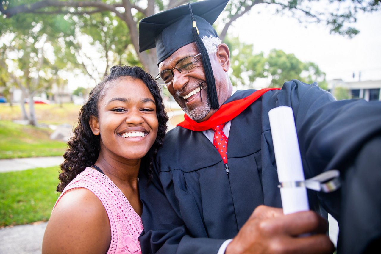 A senior African American man celebrates his graduation with his famly