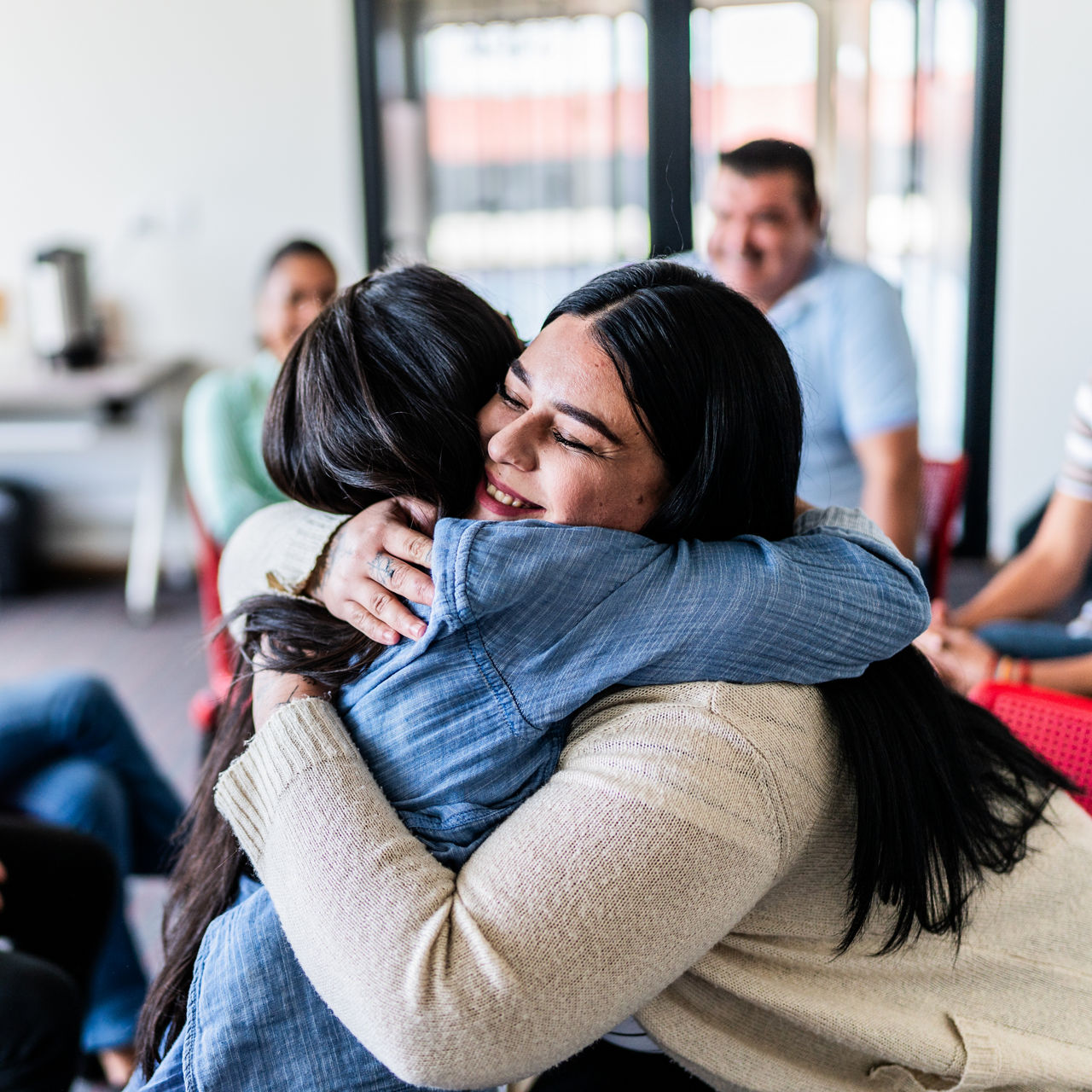 Mid adult women embracing in a group therapy
