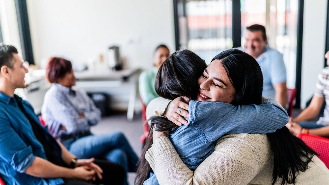 Mid adult women embracing in a group therapy