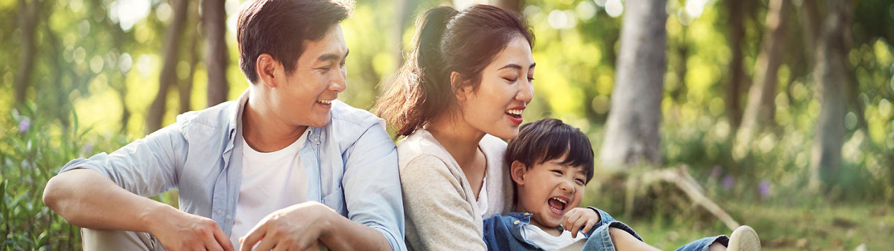 young asian parents and son having fun outdoors in park