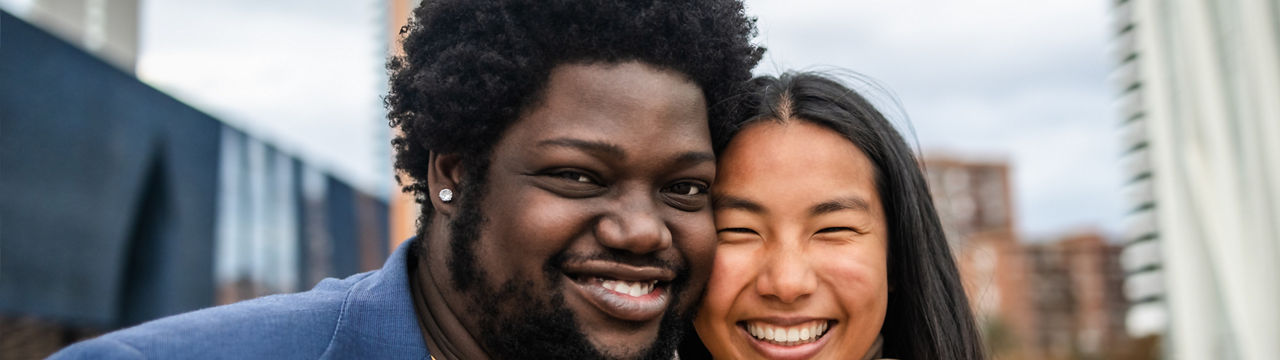 Happy young multiracial friends having fun hanging out in city