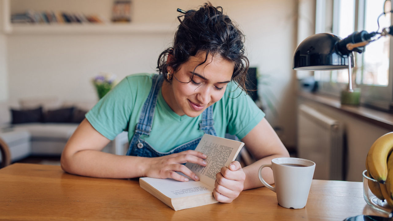 Young woman reading a book and relaxing at home.