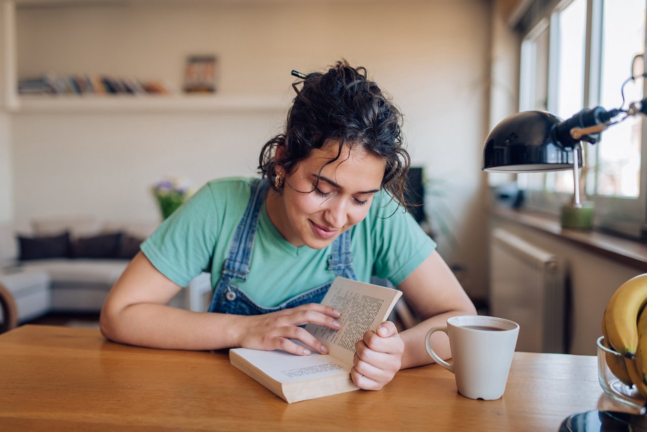 Young woman reading a book and relaxing at home.