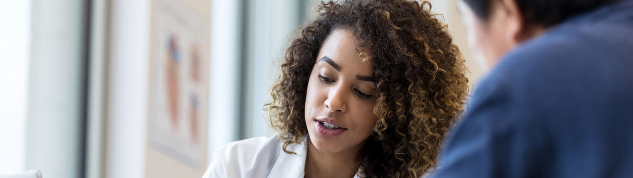 A mid-adult female doctor analyzes addiction treatment results with a colleague.