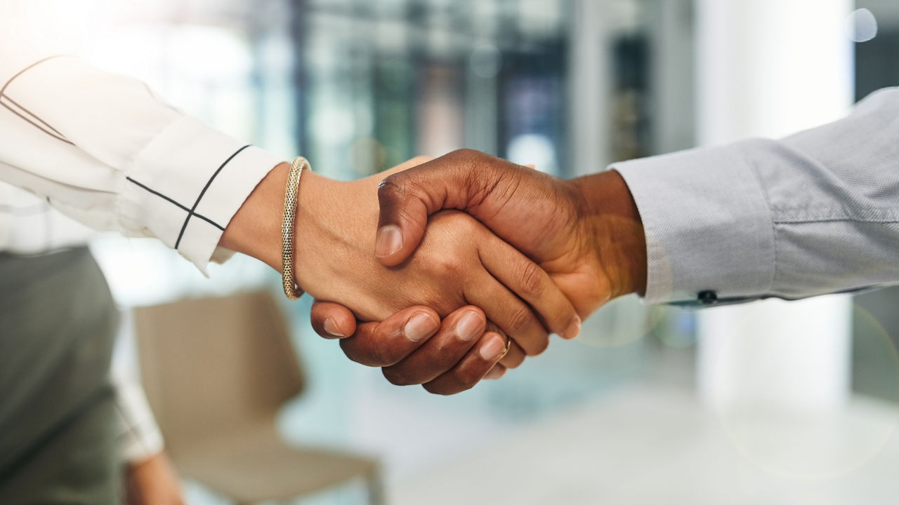 Closeup shot of two businesspeople shaking hands in an office