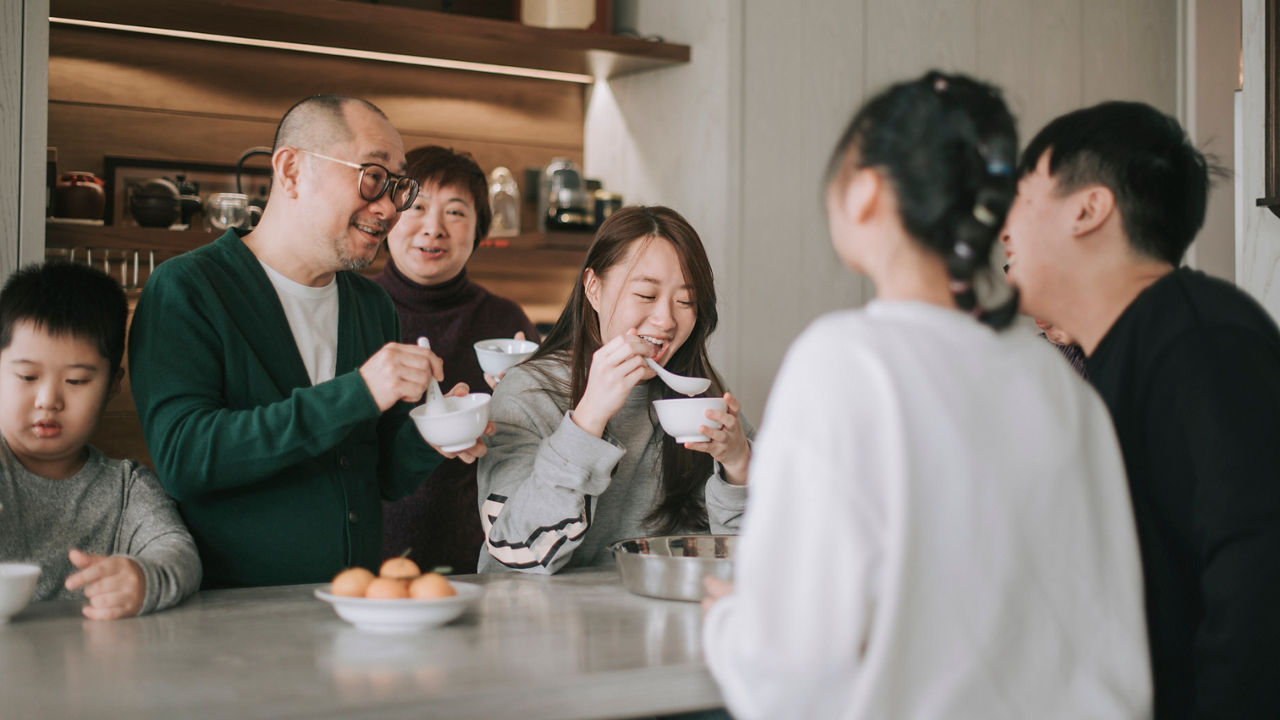 Chinese multi generation family enjoying glutinous rice ball Tang Yuan dessert during winter solstice chinese new year festival
