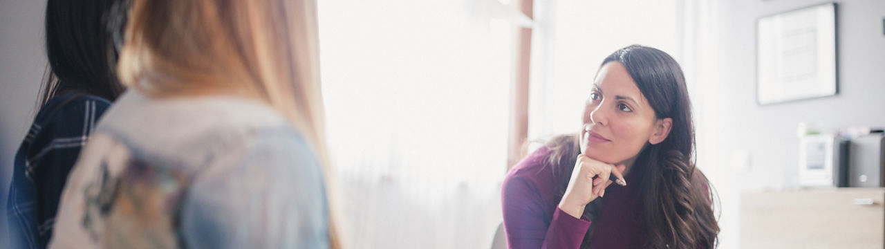 Counselor advising young lesbian couple at their home