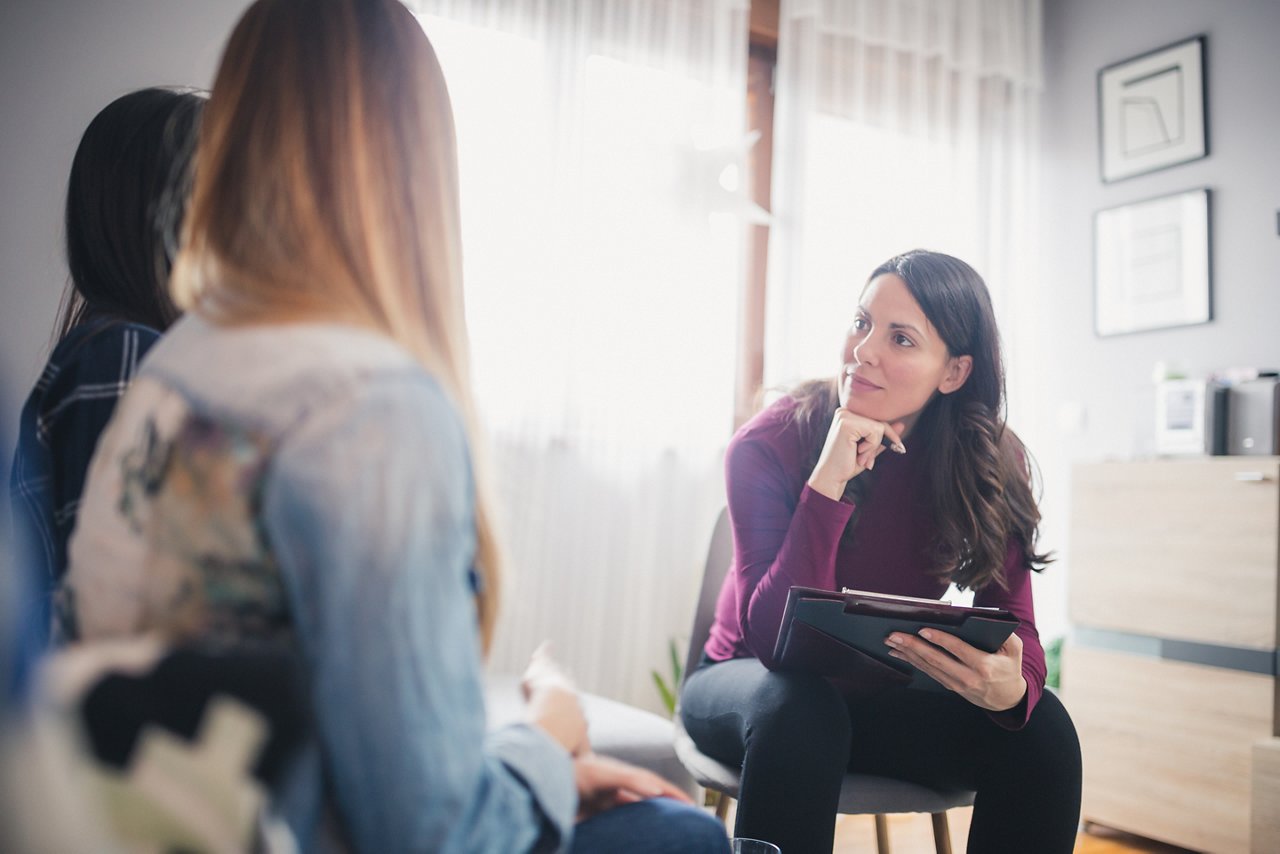 Counselor advising young lesbian couple at their home