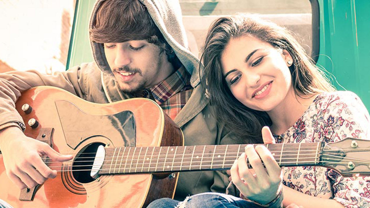 Woman leaning on man playing guitar