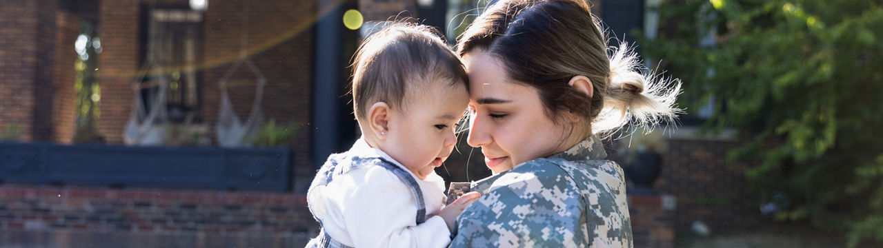 Before being deployed, the female soldier enjoys holding her daughter