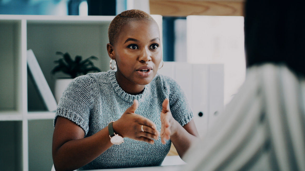 Shot of a young businesswoman having a discussion with a colleague in an office