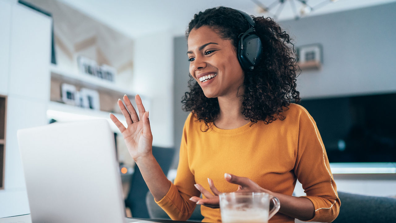 Young modern woman having video conference at home
