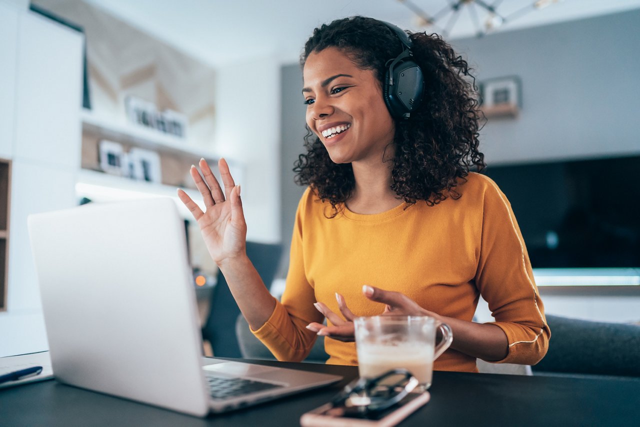 Young modern woman having video conference at home