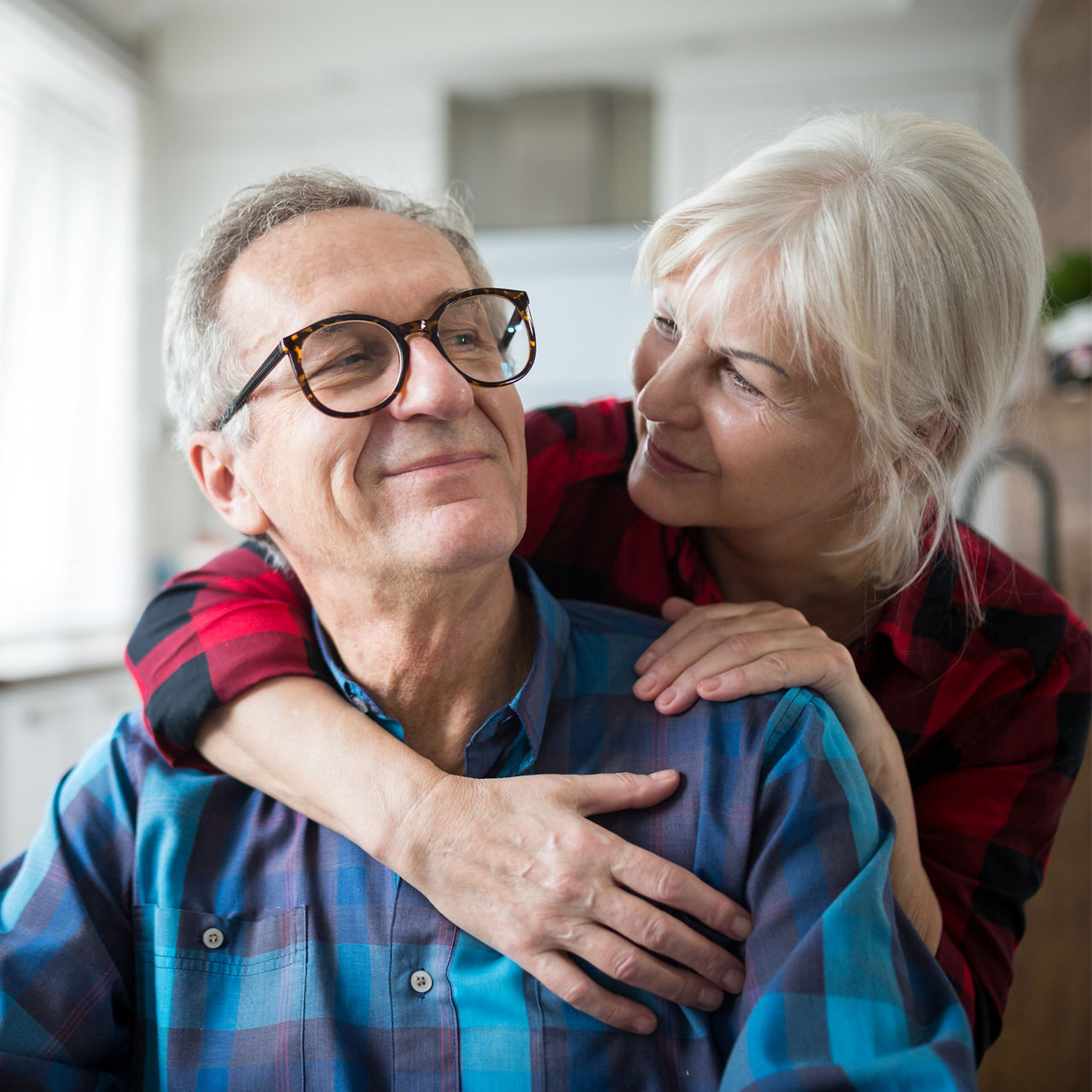 Portrait of happy senior woman embracing husband