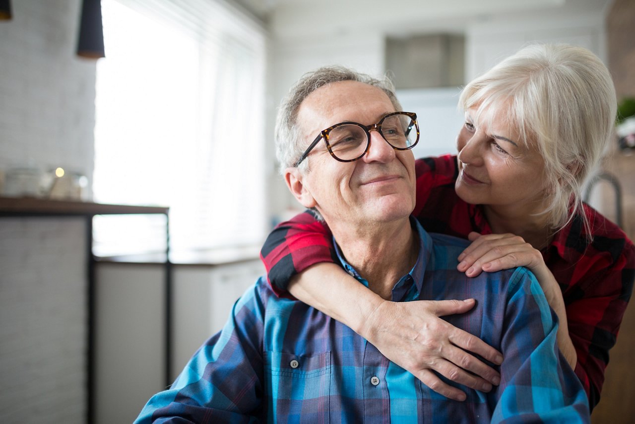 Portrait of happy senior woman embracing her husband