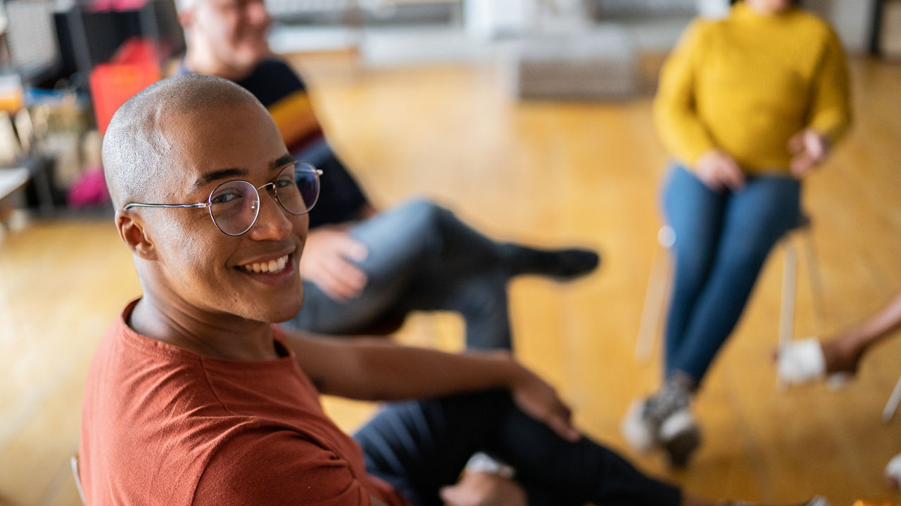 Portrait of a young man in group therapy at a coworking space