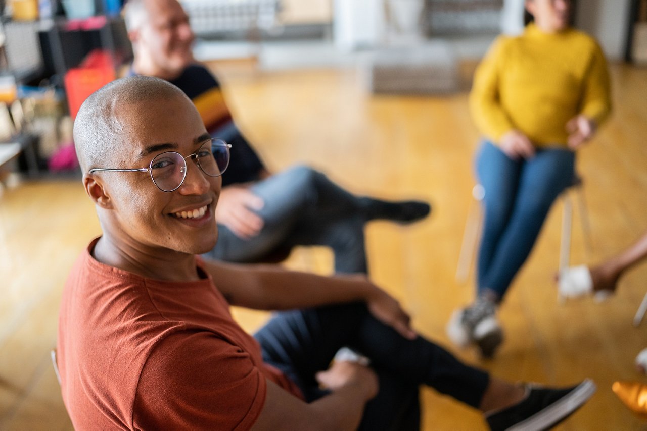 ID 319, Portrait of a young man in group therapy at a coworking