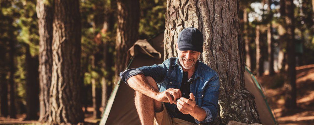 Male on cell phone while camping