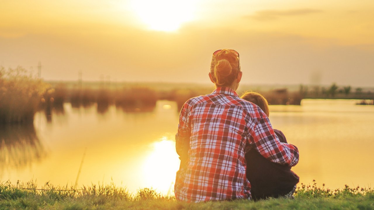 Mother and son sitting by the lake