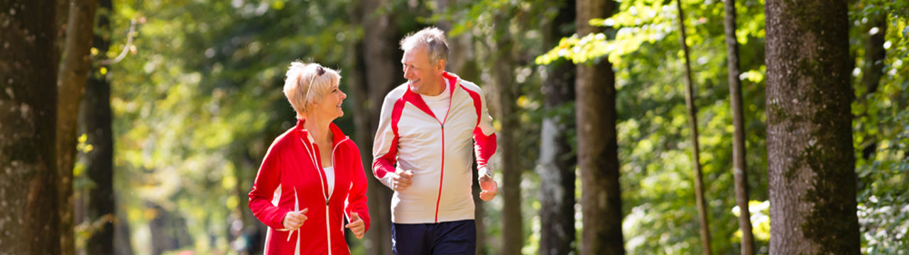 Older couple jogging woods
