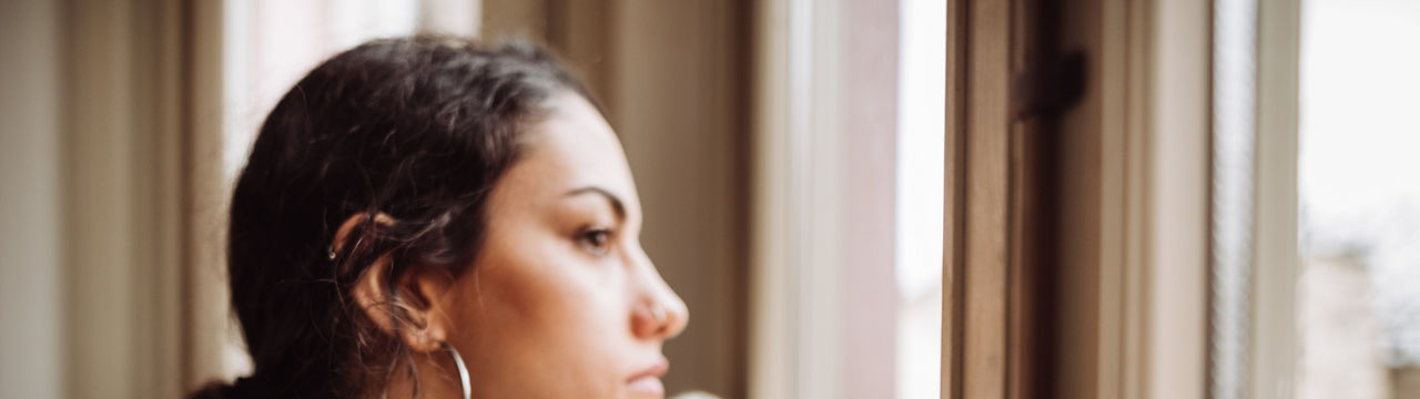 Pensive woman in front of the window