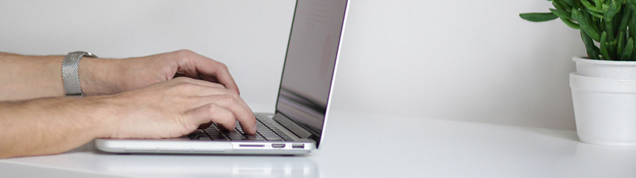 Hands on a laptop keyboard