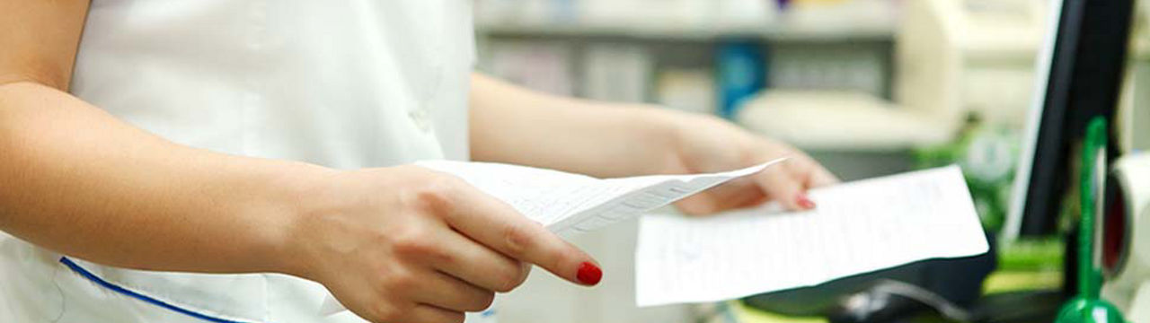 Pharmacist reviewing prescription paperwork