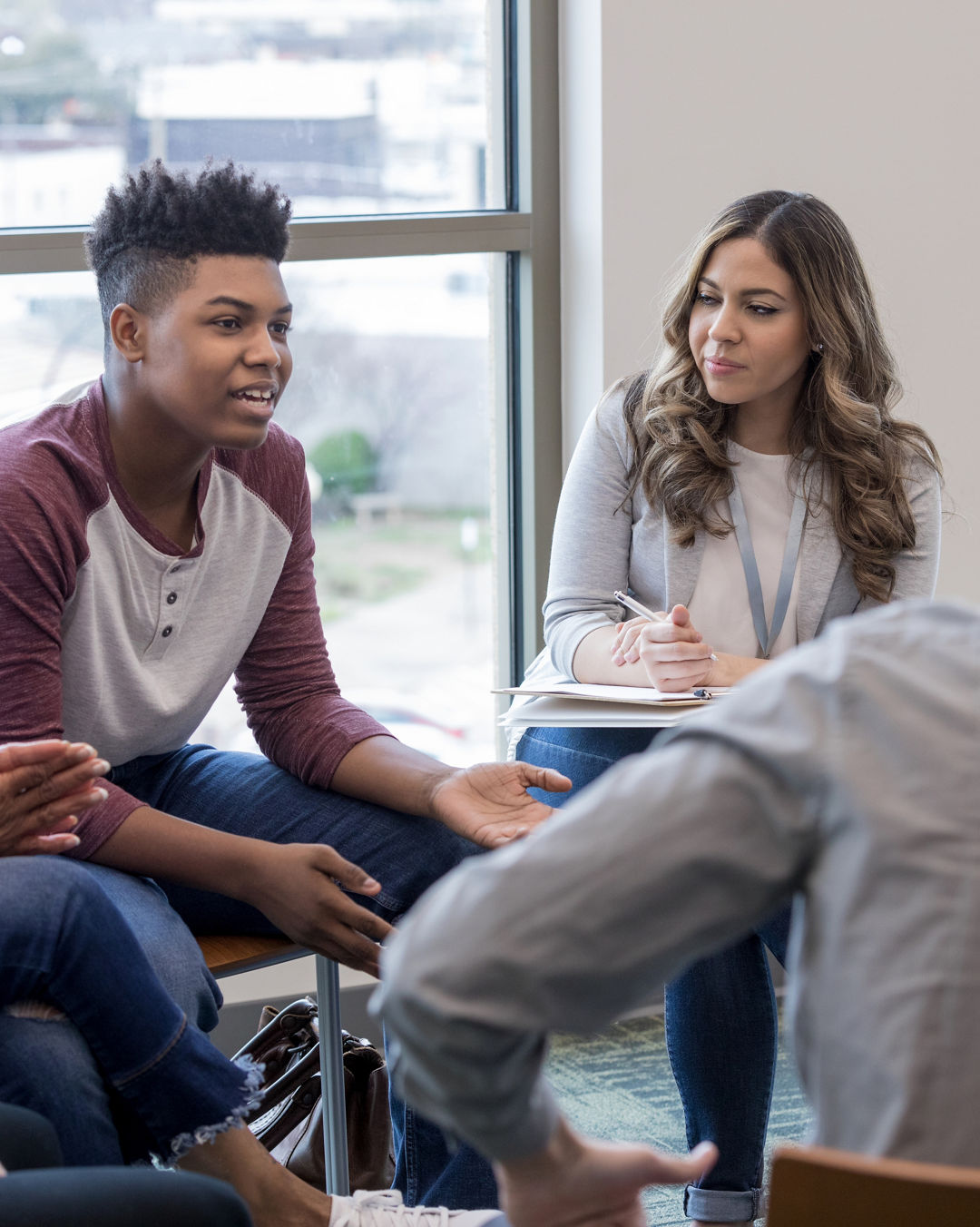 As the therapy group members listen, the teen boy shares his life experiences