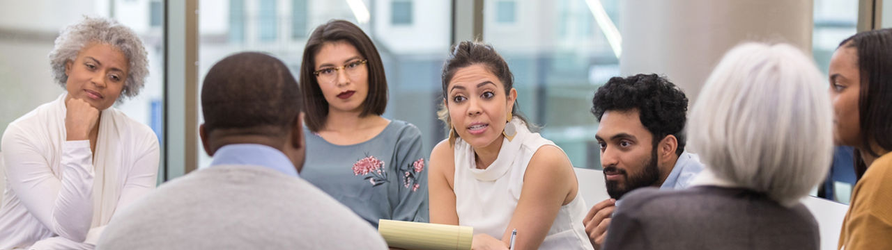 At the last session of the day, the therapist makes some strong points to an unidentified African American man while the rest of the group listens