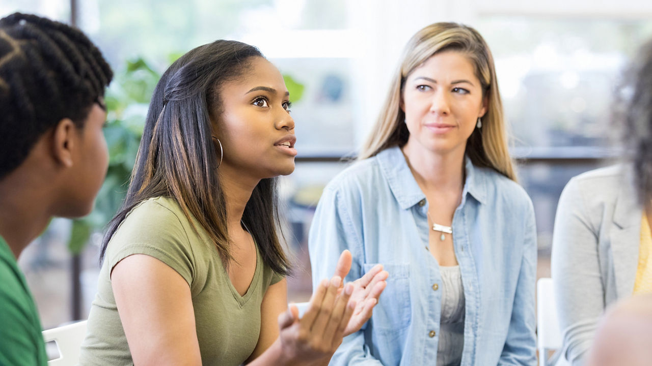 As the teen girl gestures and expresses strong emotion, everybody looks to her.