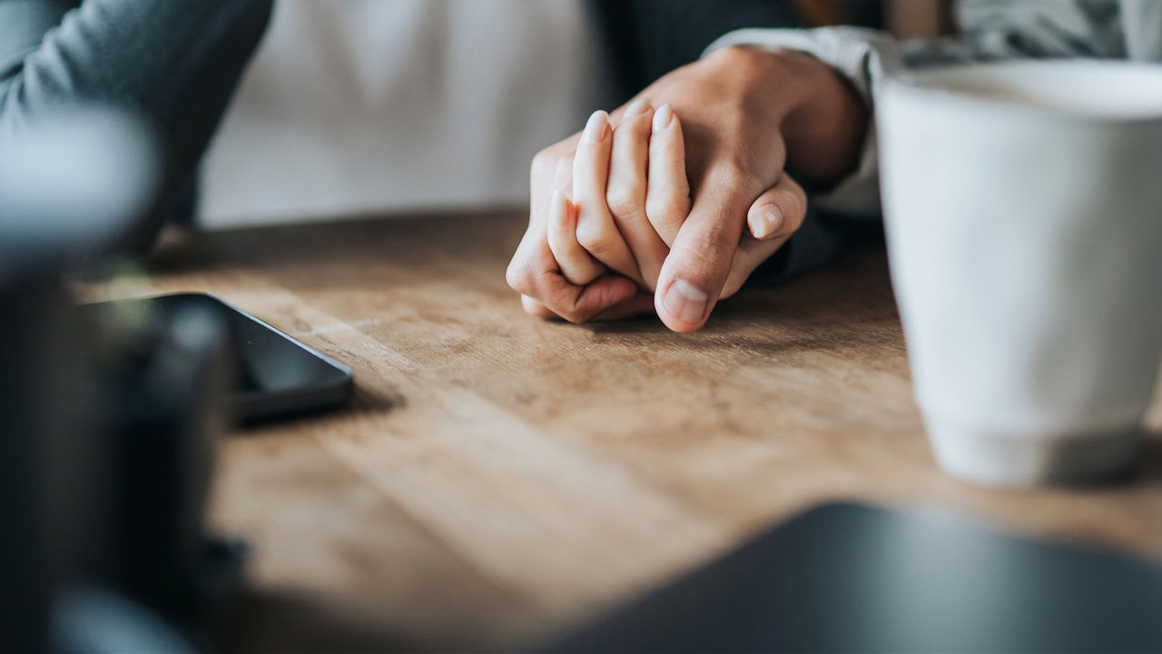 ID 328, Close up of young Asian couple on a date in cafe, holding hands on coffee table. Two cups of coffee and smartphone on wooden table. Love and care concept