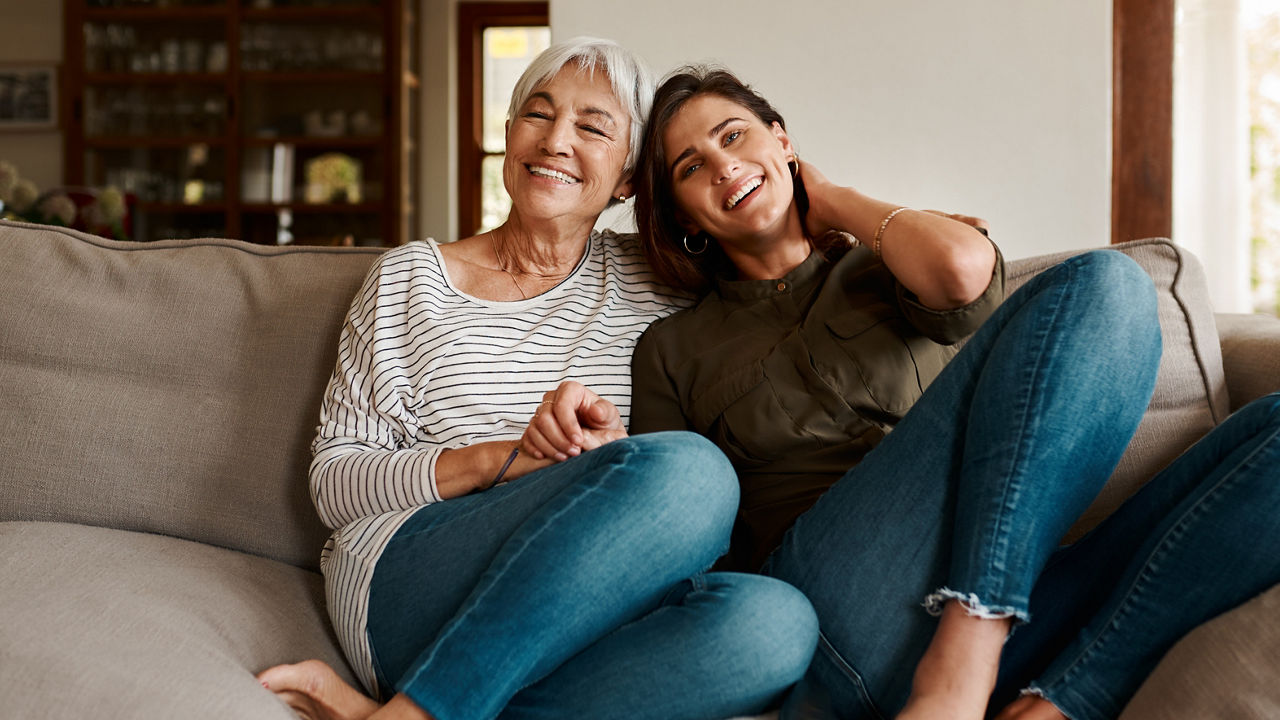 Full length portrait of an affectionate young woman spending time with her mother in their living room at home