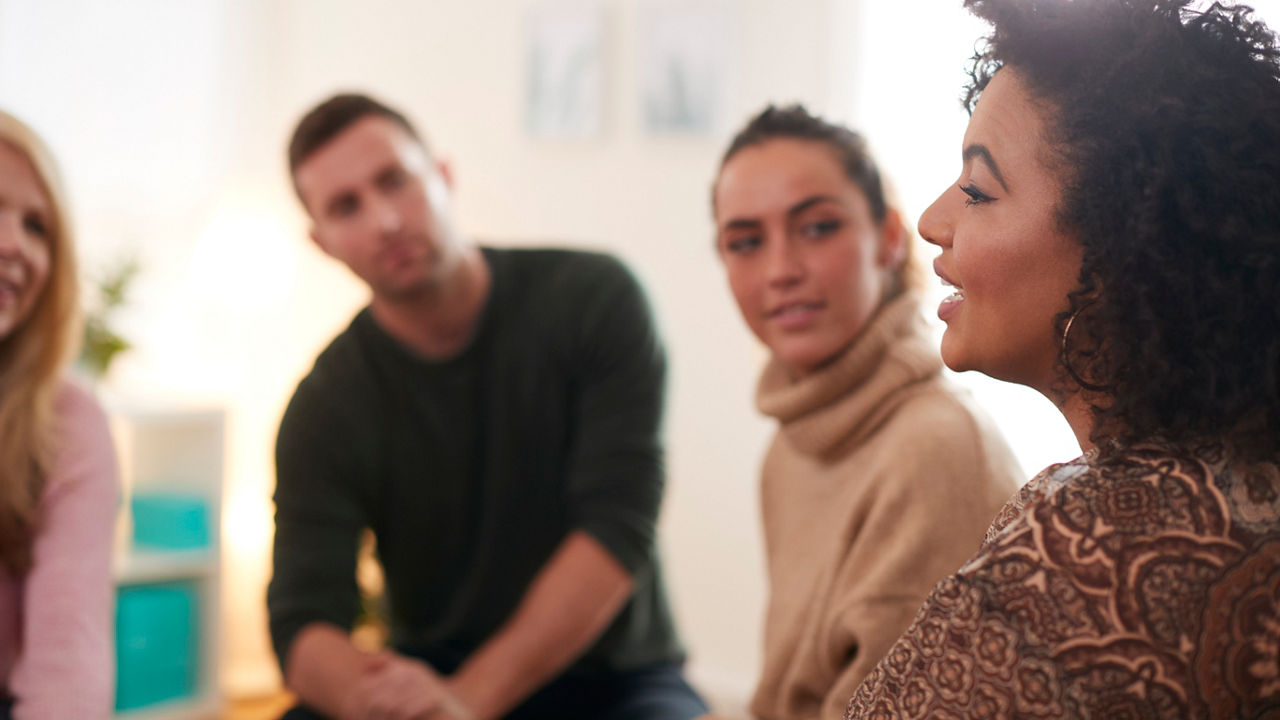 Woman Speaking At Support Group Meeting For Mental Health Or Dependency Issues In Community Space