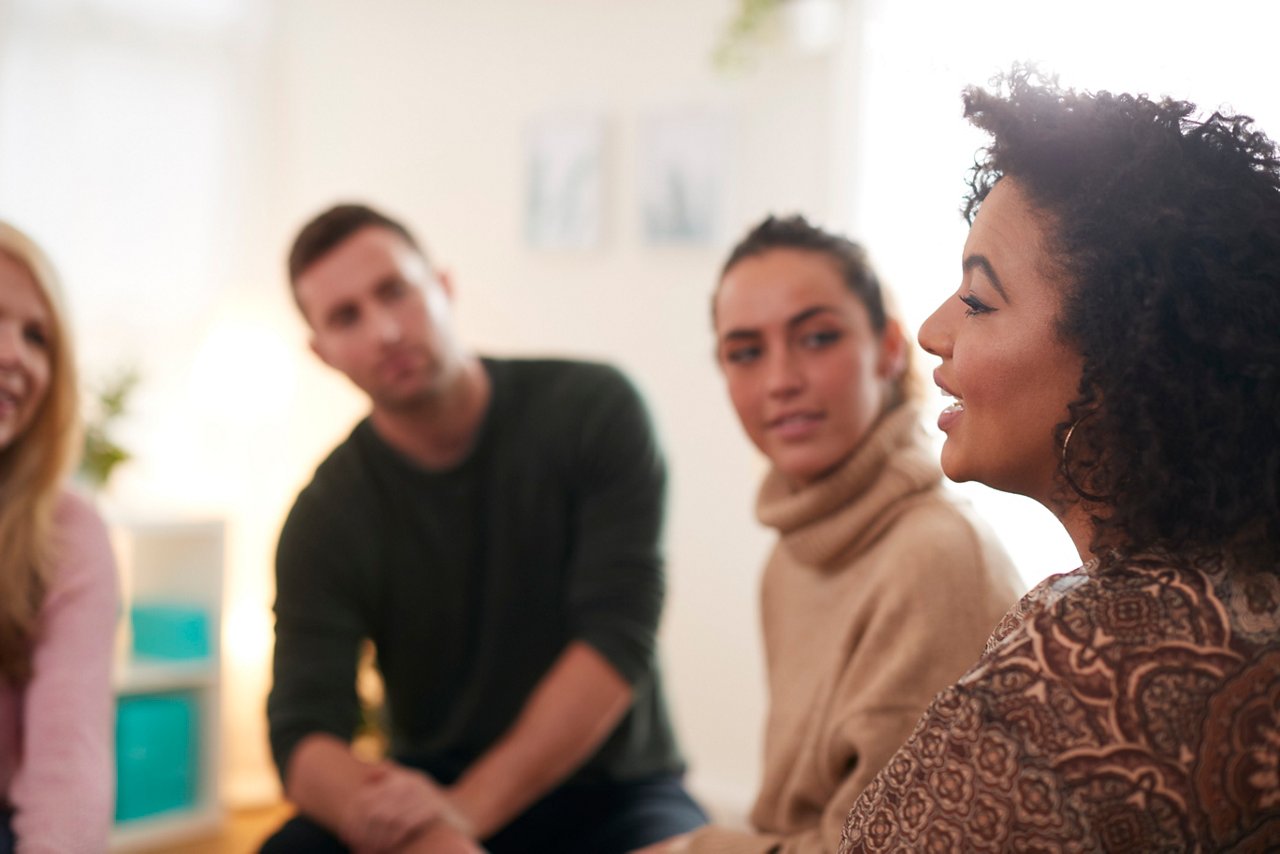 Woman Speaking At Support Group Meeting For Mental Health Or Dependency Issues In Community Space