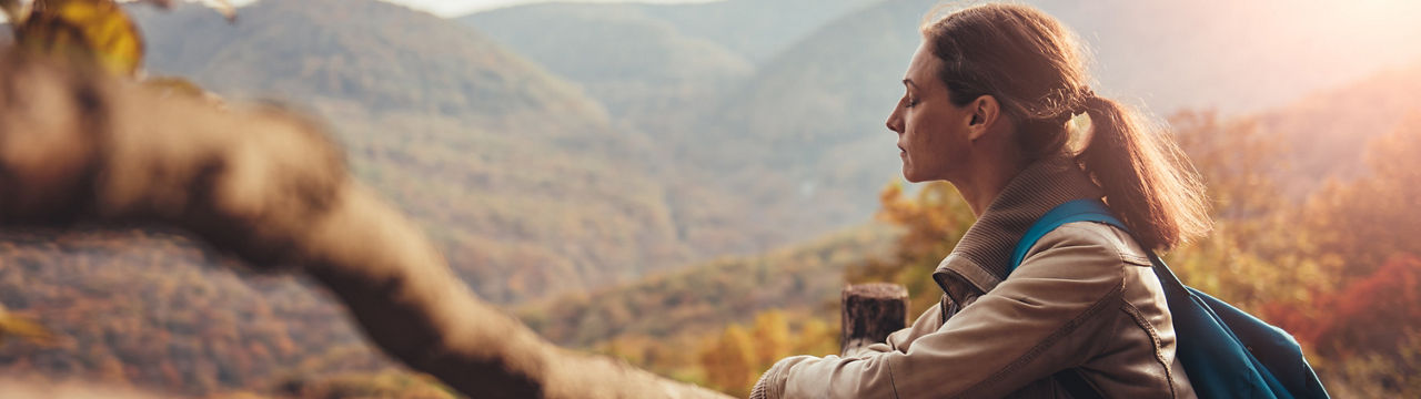 Beautiful fit young woman hiking up a mountain and enjoying at the view