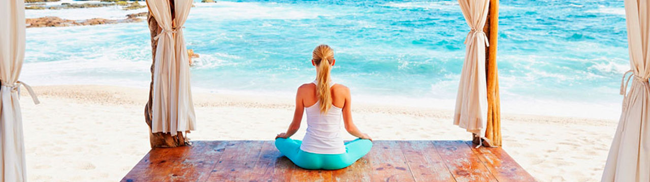 Woman meditating in front of ocean
