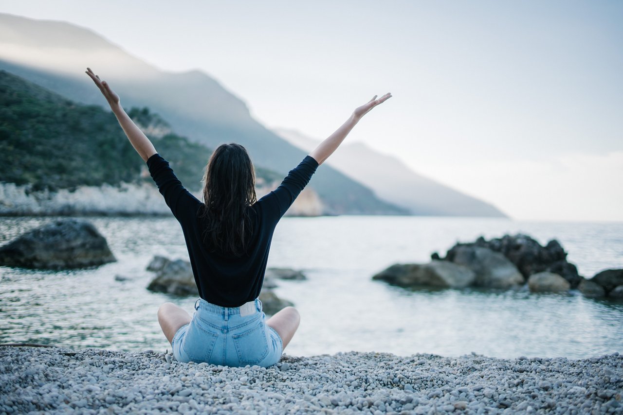 Woman in outdoors raising hands