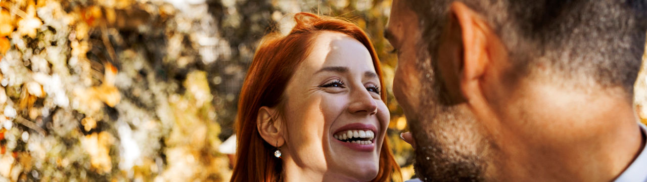 Portrait of a beautiful young couple smiling while man is embracing her