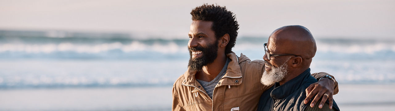 Shot of a young man going for a walk along the beach with his father