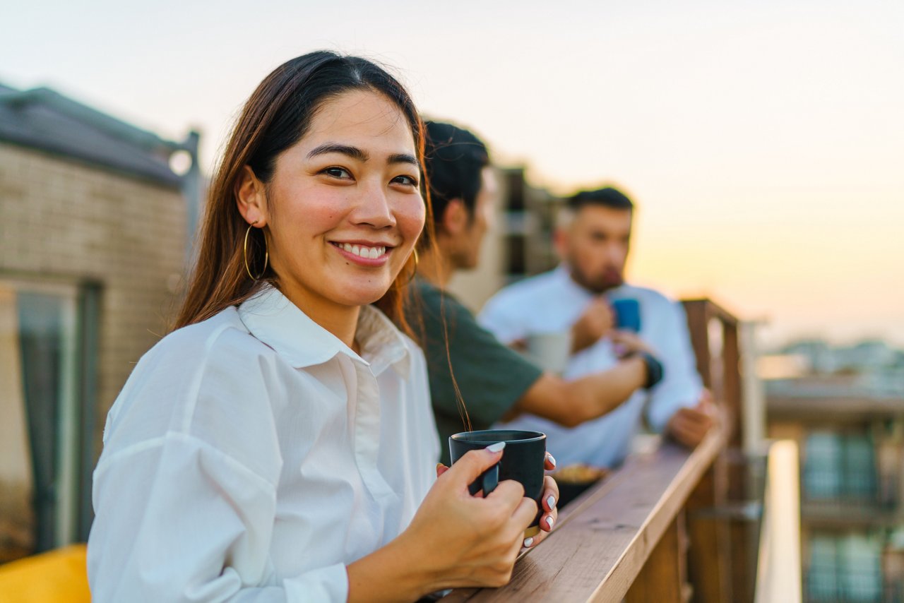 woman with coffee mug on a porch with friends