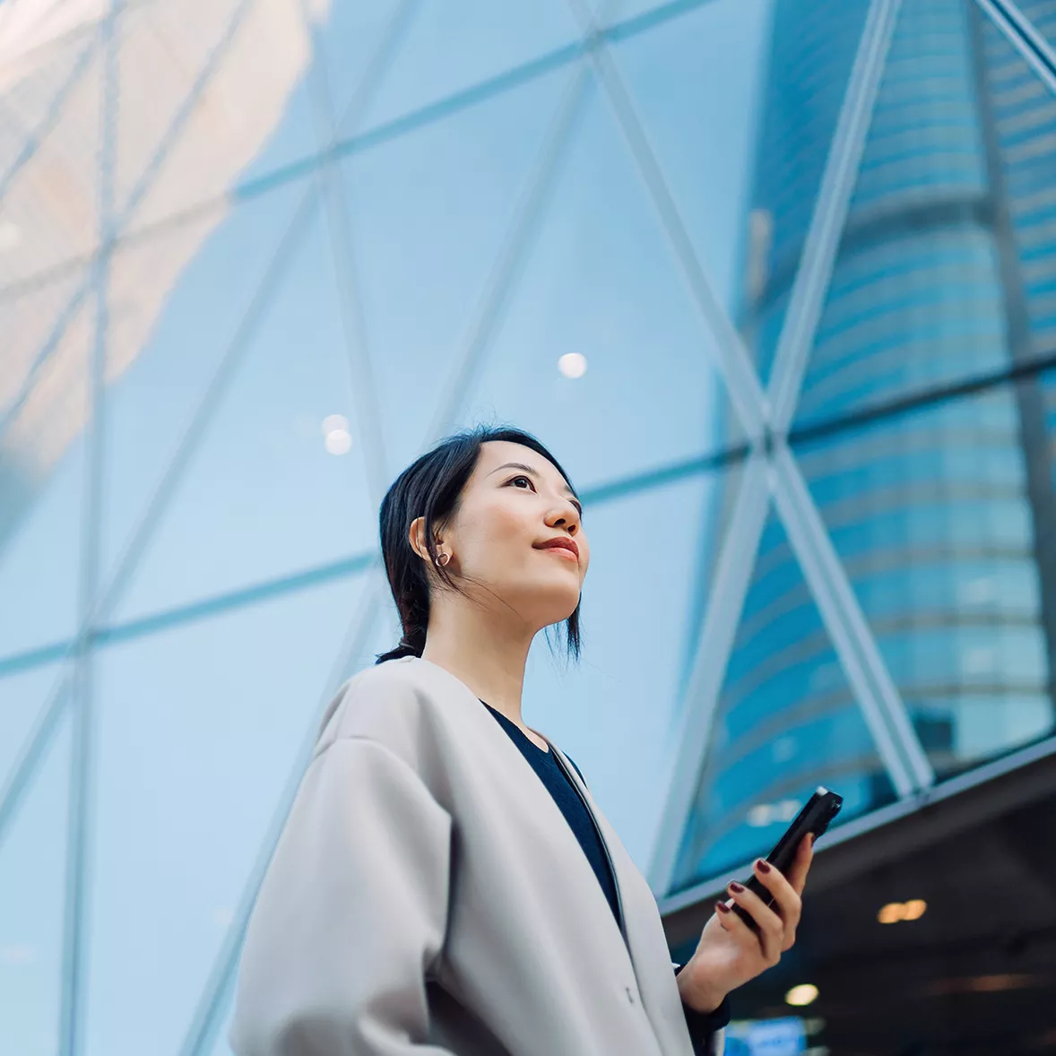 A woman looks up from her phone where she conveniently accessed the public cloud