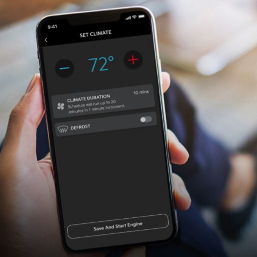 A hand holding a phone with a screen that displays the car temperature settings