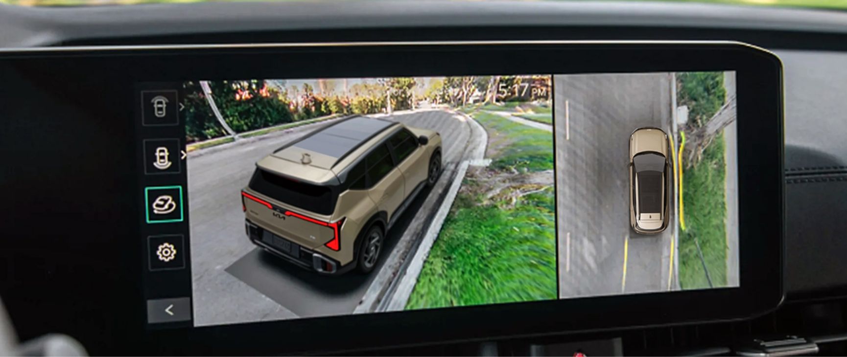 Interior shot of a Kia vehicle showing the digital display, which highlights the 360-degree surround-view monitor, currently displaying multiple views of a brown Kia vehicle and its surroundings.