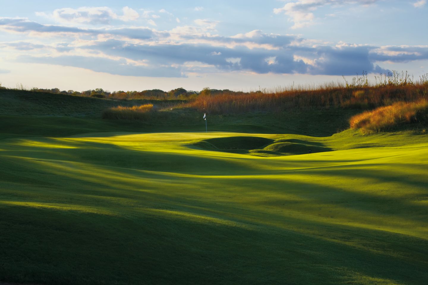 Hole 4 of the Meadow Valleys course with a golfer hitting a ball toward the green. 