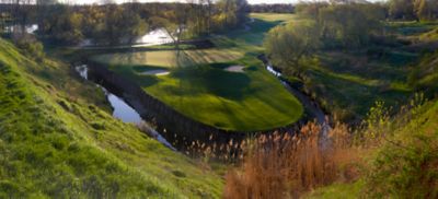 An ariel view of the green of hole 14 on the Meadow Valleys course that shows the water on three sides of the green. 