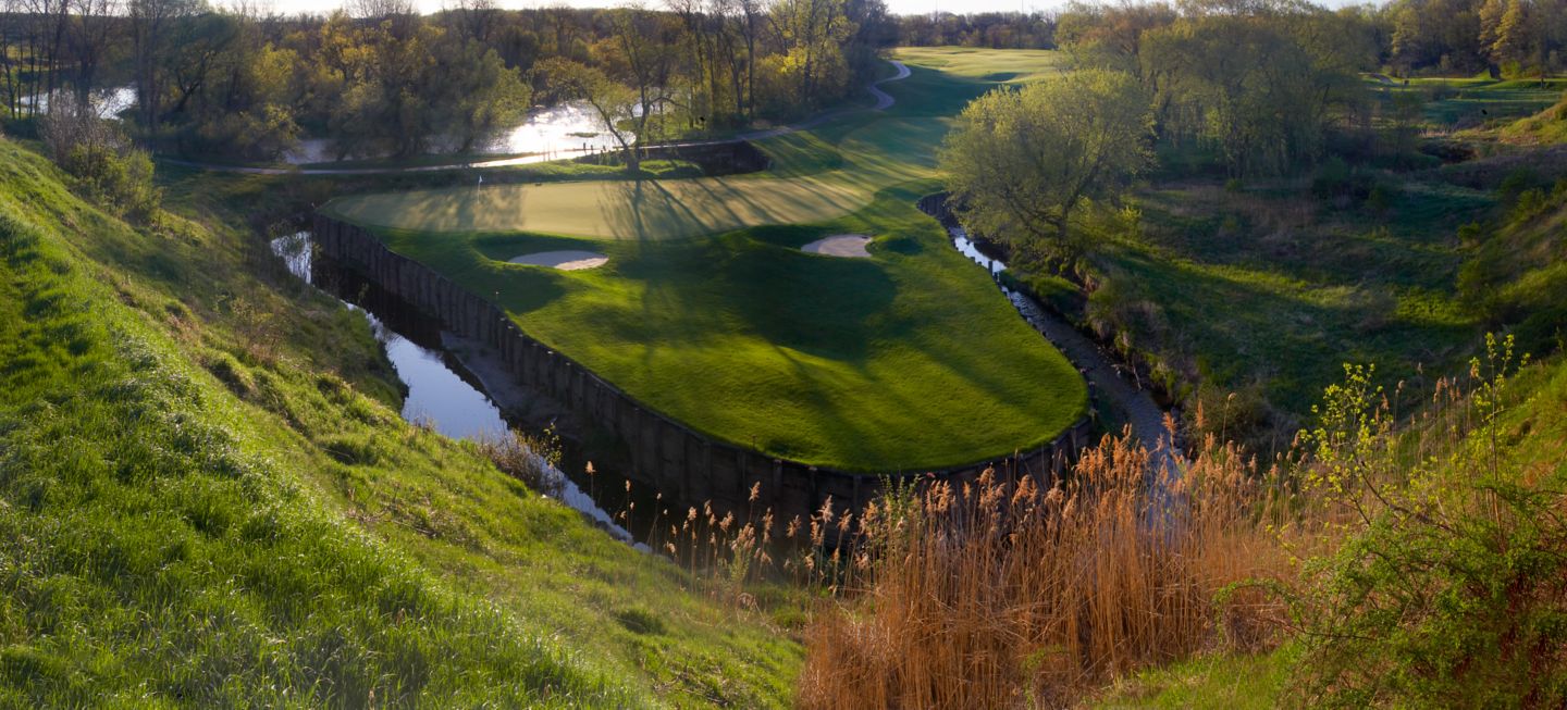An ariel view of the green of hole 14 on the Meadow Valleys course that shows the water on three sides of the green. 