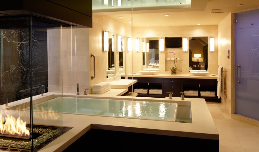 a massive bathtub with the water filling from the ceiling