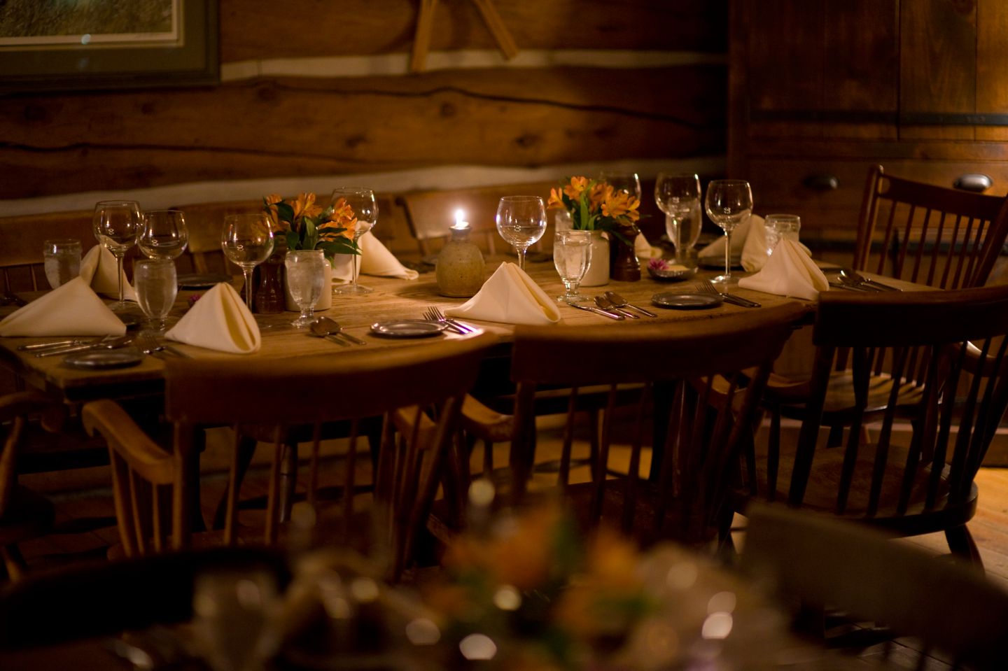 A dining table setting with a lit candle 