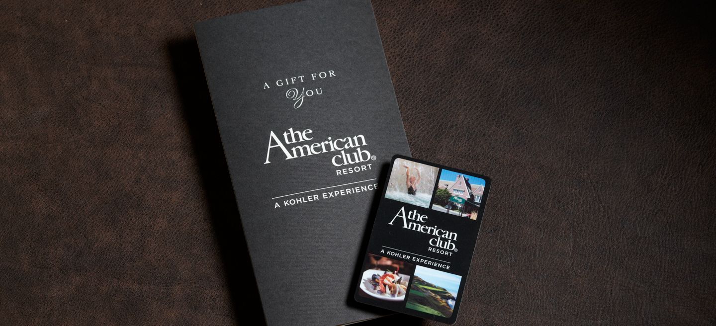 A closeup of The American Club gift card and folder on a table